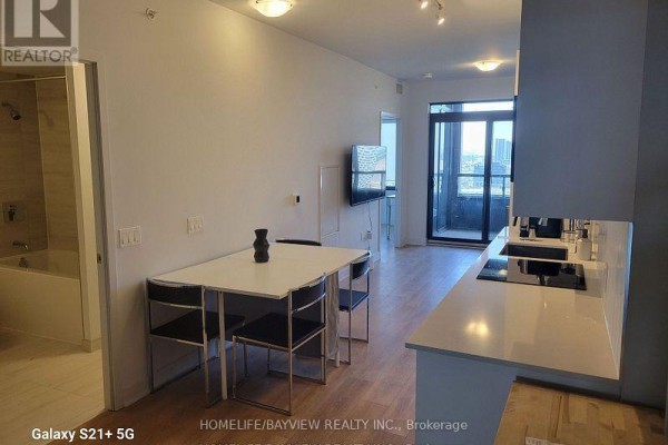 View of the kitchen, dining area, and living room, with a glimpse of a bathroom tub. - 1801 - 2920 Hwy 7 Road, Vaughan