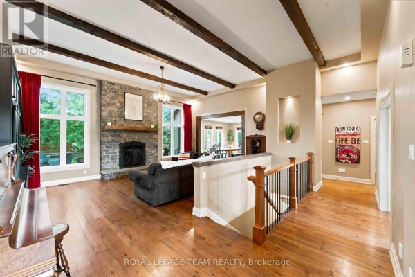 Interior view of a spacious home with hardwood floors and double glass doors leading outside. - 1801 Cedarlakes Way, Ottawa