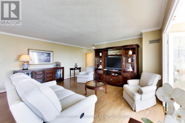 Living room featuring a sectional sofa, armchair, dark wood entertainment unit, and floor-to-ceiling windows. - 1802 - 1 Clark Avenue W, Vaughan