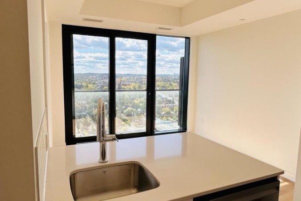 Kitchen island with stainless steel sink and faucet, featuring a large window view. - 1802 - 30 Francis Street S, Kitchener
