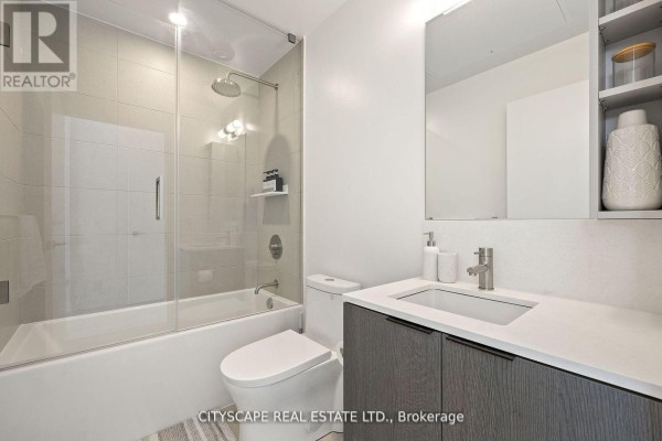 Bedroom featuring large windows, neutral bedding, and potted plant - 1802 - 55 Mercer Street S, Toronto
