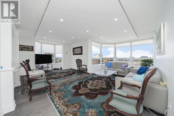 Living room with sectional sofa, large rug, TV, and city view - 1802 - 8 Lisa Street Brampton