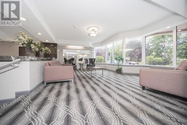 Sitting area with sofas, armchairs, and large windows - 1802 - 8 Lisa Street Brampton