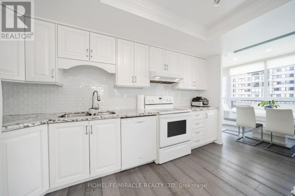 White kitchen with granite countertops, subway tile backsplash, and dining area - 1802 - 8 Lisa Street Brampton