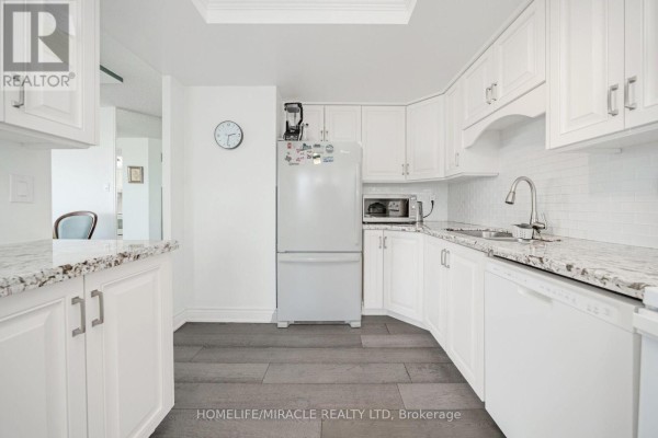 White kitchen with granite counters, subway tile backsplash, and wood floors - 8 Lisa Street Brampton