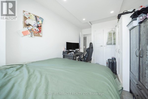 Bedroom with bed, desk, gaming chair, monitors, and wardrobe - 1802 - 8 Lisa Street Brampton