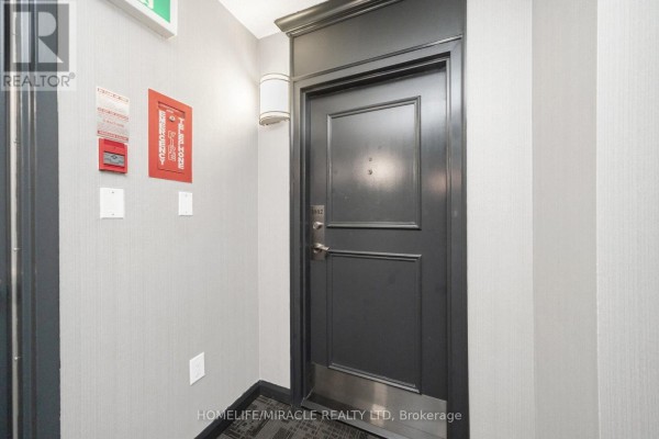Hallway with door #1802, fire alarm, and wall sconce - 1802 - 8 Lisa Street Brampton