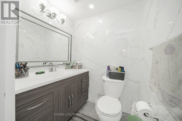 Modern bathroom vanity with marble tile and toilet - 1802 - 8 Lisa Street Brampton