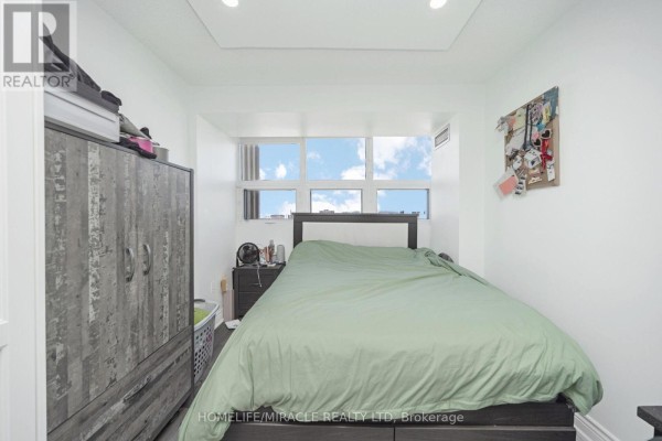 Bedroom with bed, wardrobe, and window view - 1802 - 8 Lisa Street Brampton