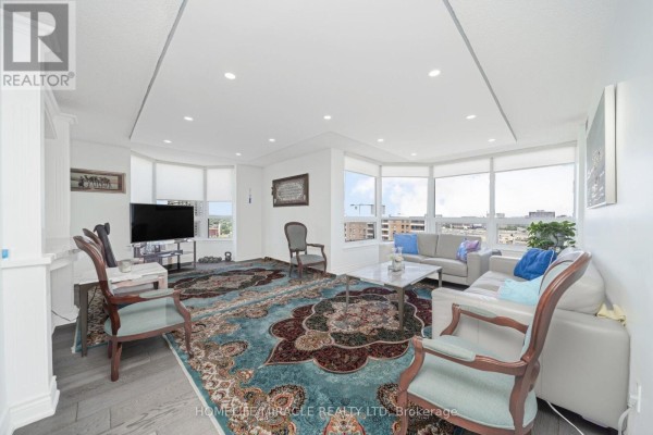 Living room with bay windows, sofa, rug, and TV - 1802 - 8 Lisa Street Brampton