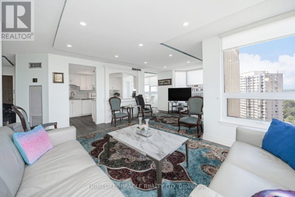 Living room with leather sofas, marble coffee table, ornate rug, and city view - 1802 - 8 Lisa Street Brampton