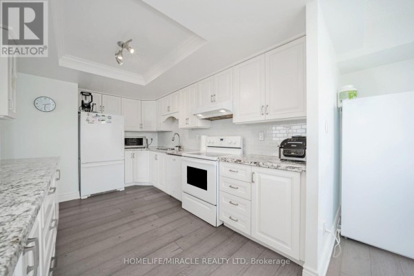 White kitchen with granite countertops and subway tile backsplash - 1802 - 8 Lisa Street Brampton