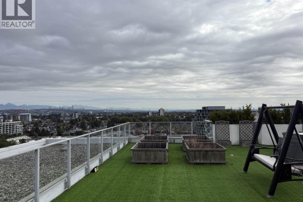 Rooftop patio with artificial grass, planter boxes, and swing chair overlooking city. - 1802 3333 Brown Road, Richmond