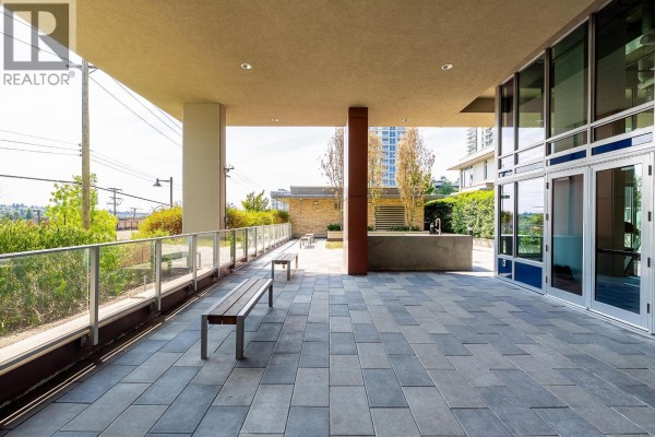 Entryway with white walls, shoe storage, and double doors leading to the apartment. - 1803 518 Whiting Way, Coquitlam