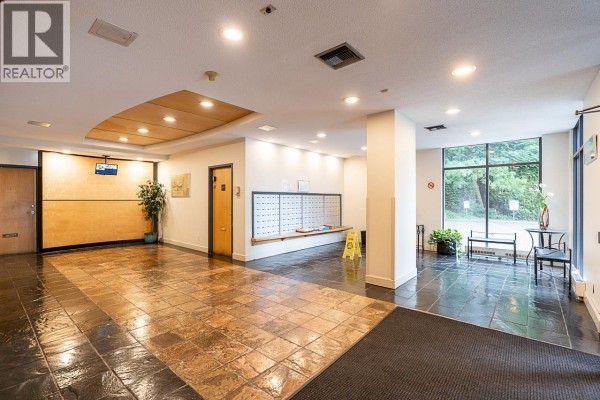 Interior view of the apartment building lobby with mailboxes and seating. - 1803 7077 Beresford Street, Burnaby