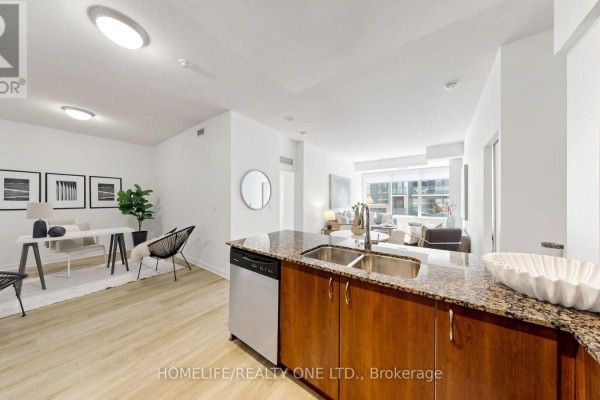 View from kitchen island to dining area, desk, and living room. - 1804 - 55 East Liberty Street, Toronto