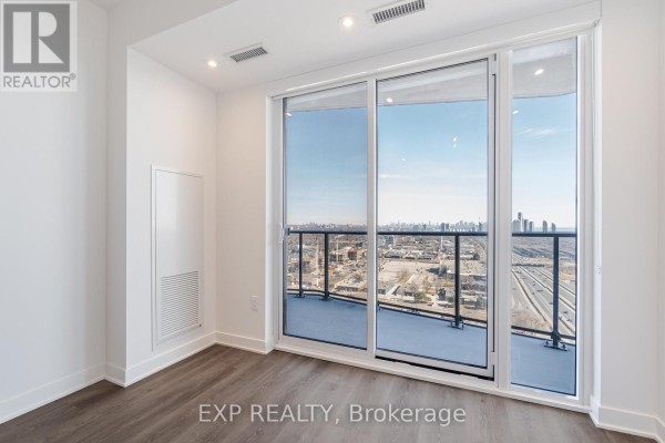Living area with sliding glass doors to balcony and city view. - 1805 - 36 Zorra Street, Toronto