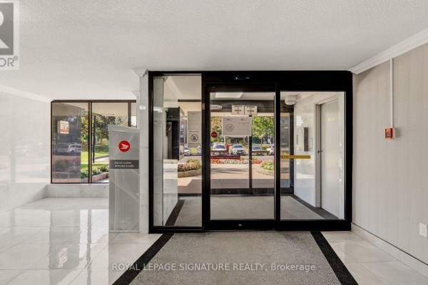 Interior view of the building's lobby entrance with automatic glass doors and tiled flooring. - 1805 - 4 Kings Cross Road, Brampton