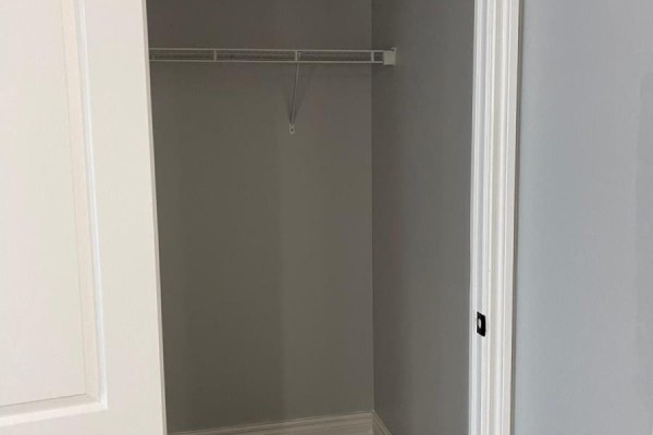 Empty walk-in closet with grey walls and a single wire shelf, viewed from doorway. - 1805 - 70 Town Centre Court, Toronto