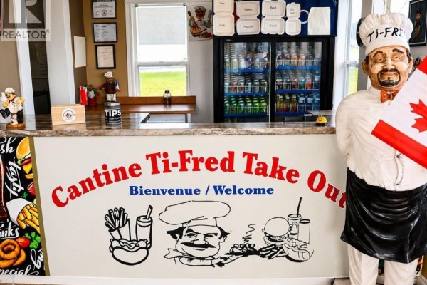 Counter view inside the take-out restaurant with a beverage cooler and a statue of a chef holding a Canadian flag. - 1805 Route 322, Robertville