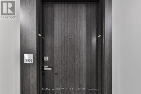 Close-up of the apartment door marked '1806' with a modern finish and security features. - 1806 - 15 Queen Street, Hamilton