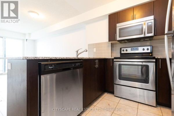 Kitchen with stainless steel dishwasher, oven, microwave, and dark wood cabinets. - 1808 - 1410 Dupont Street, Toronto