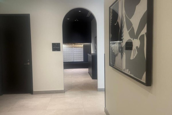 Hallway with black doors, arched doorway leading to a space with glass block windows. - 1809 - 225 Malta Avenue, Brampton
