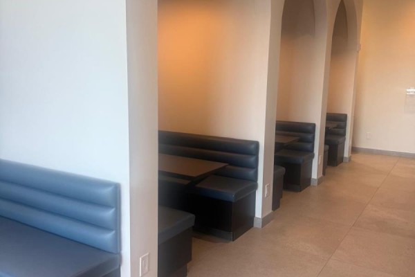 Dining area with black leather booths and tables arranged in arched alcoves. - 1809 - 225 Malta Avenue, Brampton