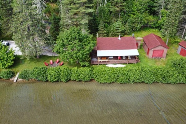 Property view from above showing cottage, garage, trees, and waterfront lawn. - 181 Ch. Du Petit-cayamant, Cayamant
