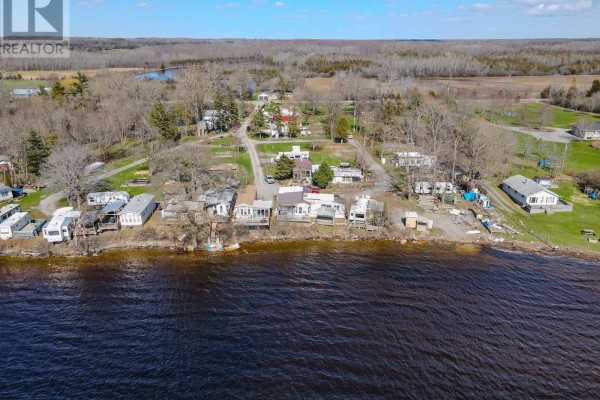 Aerial view of a property with numerous mobile homes, cabins, and scattered buildings. - 181 Melville Road, Prince Edward County