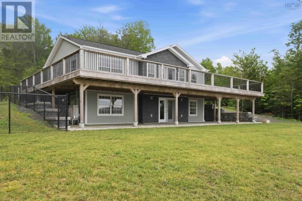 Bright living room with large windows, sliding doors, and a mounted TV - 181 Timberland Road, South Range