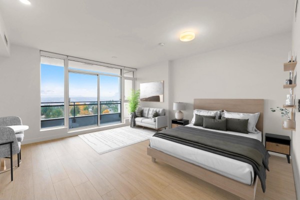 Bright bedroom with a large window, balcony access, and minimalist decor including a bed and seating area. - 1810 13675 107a Avenue, Surrey