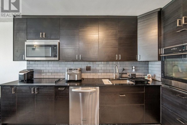 Living area featuring large windows, modern decor, and a view of the city skyline - 1811 - 10 Martha Eaton Way, Toronto