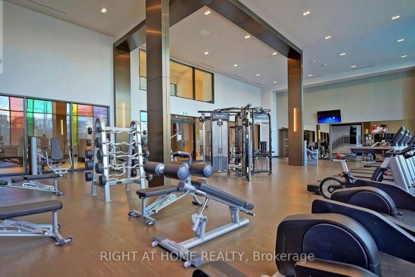 Well-equipped gym with treadmills, weight machines, and free weights. - 1812 - 38 Gandhi Lane, Markham