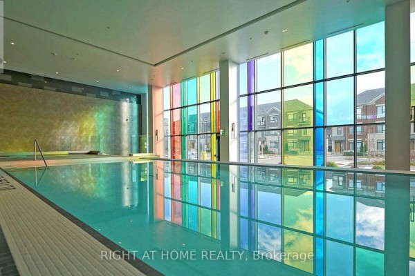 Indoor swimming pool with colorful glass windows casting reflections on the water. - 1812 - 38 Gandhi Lane, Markham