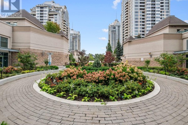 Circular paved walkway with a landscaped garden in the center, surrounded by buildings. - 1814 - 17 Barberry Place, Toronto
