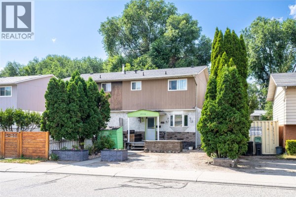 Bedroom with light green walls, hardwood floors, and a wall-mounted television. - 1816 43 Street, Vernon