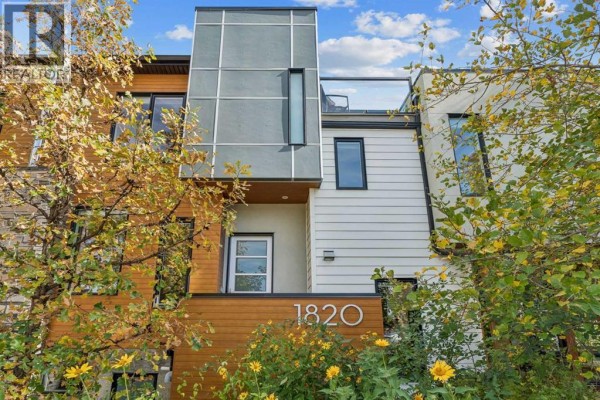 Front exterior of the duplex with address number 1820, featuring wood, glass, and greenery. - 1820 4 Street Ne, Calgary