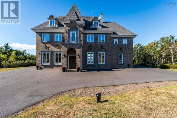 Large stone house with a circular driveway and manicured lawn under a blue sky. - 1820 Culloden Road, Culloden