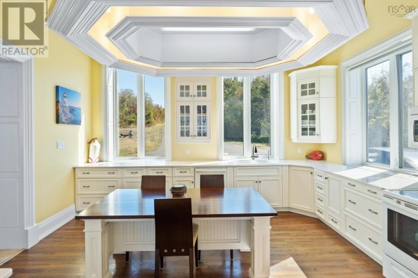 Kitchen nook with a wooden table and chairs next to large bay windows. - 1820 Culloden Road, Culloden