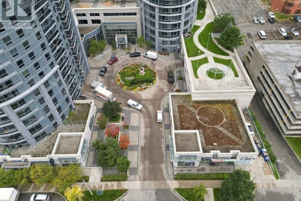 Aerial view of a circular driveway and courtyard between apartment buildings with green rooftop gardens. - 1822 - 135 Village Green Square, Toronto