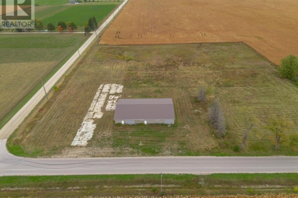 Aerial view shows a commercial building situated on a rural property with surrounding agricultural fields and roads. - 1822 Concession 12 Concession, Huron Kinloss