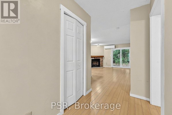 Hallway leading to an open-concept living area with a fireplace and sliding glass doors. - 183 - 49 Trott Boulevard, Collingwood
