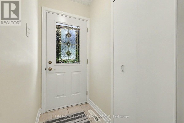 Interior view of a front entryway with a white door, stained glass window, and closet. - 183 Martin Avenue, Ottawa