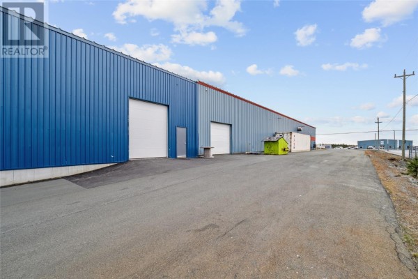 Close-up of the blue exterior wall with loading doors and adjacent road. - 183 Mcnamara Drive, Paradise