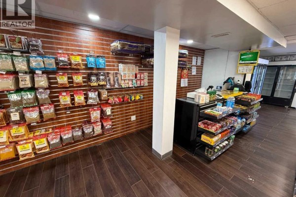 Refrigerated beverage coolers and glass display cases filled with products in a retail store setting. - 183 Pembina Avenue, Hinton