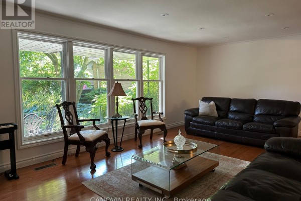 Rear view of the brick house with large windows, patio, and backyard. - 183 St. Anthony's Court, Richmond Hill