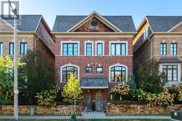 Front exterior of brick townhouse with arched windows and landscaping. - 1831 Pagehurst Avenue, Mississauga