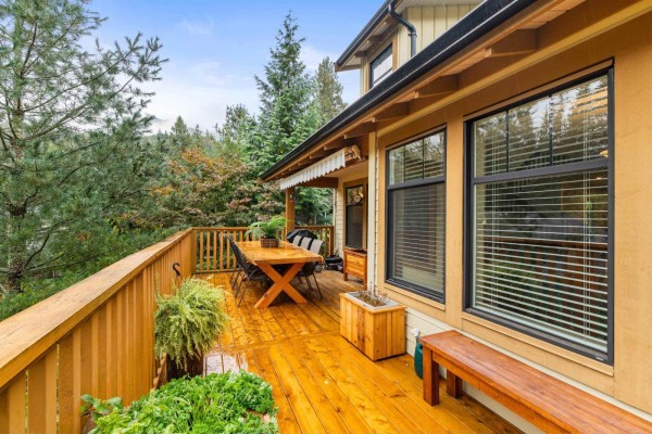Wooden deck with outdoor dining table and chairs, surrounded by trees. - 1832 Huckleberry Bend, Cultus Lake South, Cultus Lake