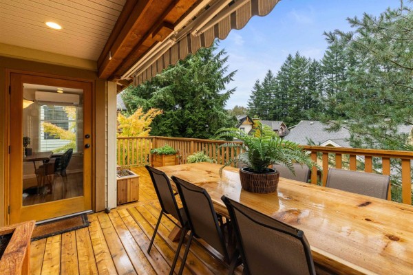 Covered deck with dining table and chairs, view of the backyard. - 1832 Huckleberry Bend, Cultus Lake South, Cultus Lake